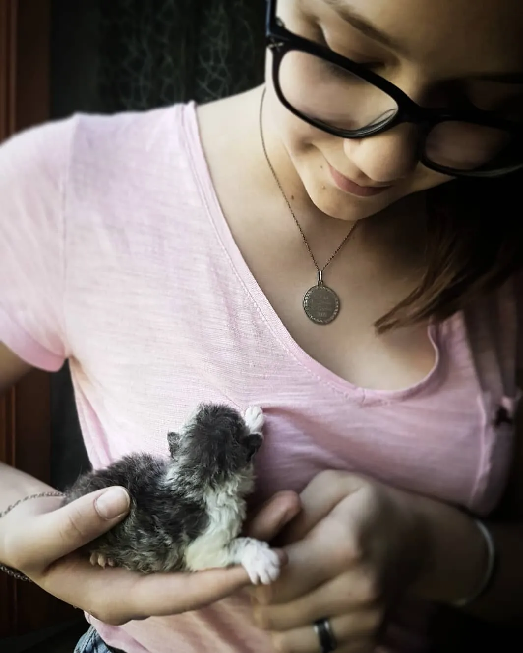 Alt Text: Un gatto Selkirk Rex cucciolo insieme alla sua famiglia umana, simbolo di un'adozione di un gatto di razza felice.